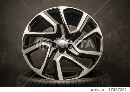 new stylish cool alloy wheel on the tire dark textured background, beautiful and expensive front view 20 -21, 22 diameter new stylish cool alloy wheel on the tire dark textured background, beautiful and expensive front view 20 -21, 22 diameter 87867202