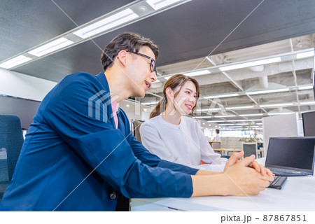 フリーアドレスのオフィスで仕事をするビジネスマンとビジネスウーマン 87867851
