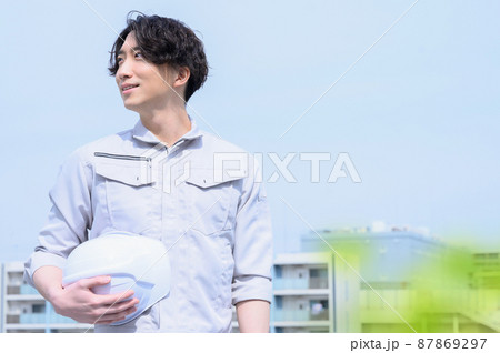 作業着姿で空を見る男性　前ボケあり 87869297