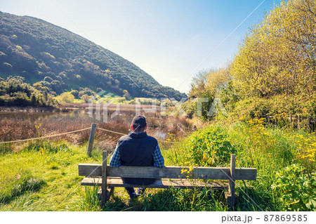 A man tourist looks at the picturesque wildlife. Natural Reserve (Natural Resources) Marisma de Joyel. Cantabria, Spain A man tourist looks at the picturesque wildlife. Natural Reserve (Natural Resources) Marisma de Joyel. Cantabria, Spain 87869585