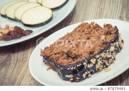 Pastry made of zucchini with nuts and raisin on plate. Delicious dessert Pastry made of zucchini with nuts and raisin on plate. Delicious dessert 87870461