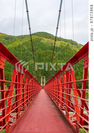 秋葉ダム直下の天竜川に架かる赤い吊り橋　竜山橋（静岡県浜松市） 87873868