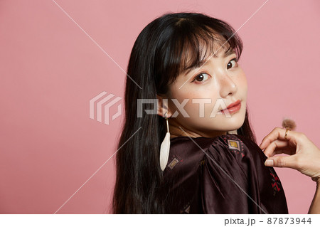 そばかすメイクをした若い女性のピンク背景のポートレート そばかすメイクをした若い女性のピンク背景のポートレート 87873944