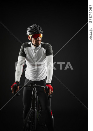 male cyclist with road bicycle on black background male cyclist with road bicycle on black background 87874067