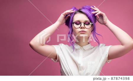 bright girl with purple hair wearing glasses portrait on pink background bright girl with purple hair wearing glasses portrait on pink background 87874398
