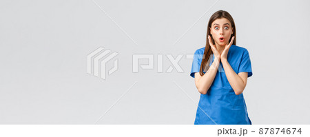 Healthcare workers, prevent virus, insurance and medicine concept. Surprised nurse or female doctor in blue scrubs, gasping look worried, hear about new covid-19 patient got sick, stare camera 87874674