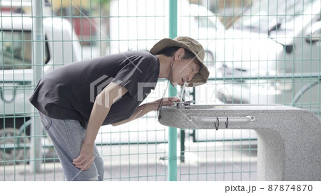 公園で水を飲む男性 87874870
