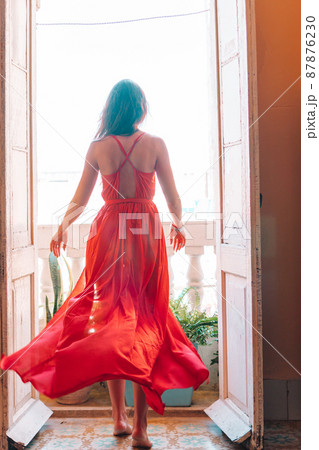 Young attractive woman in red dress on old balcony in apartment in Havana 87876230