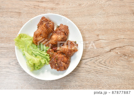 spicy crispy fried chicken drum wing with lemon leaf sauce and vegetable on plate 87877887