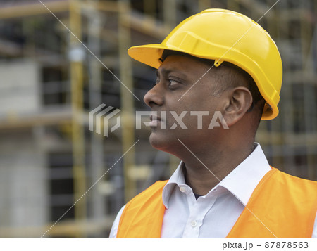 Profile portrait of a serious civil engineer or factory worker wearing a safety helmet and looking aside Profile portrait of a serious civil engineer or factory worker wearing a safety helmet and looking aside 87878563