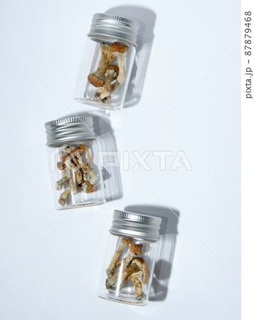 Psilocybin psychedelic magic mushrooms in glass jar on white background Psilocybin psychedelic magic mushrooms in glass jar on white background 87879468