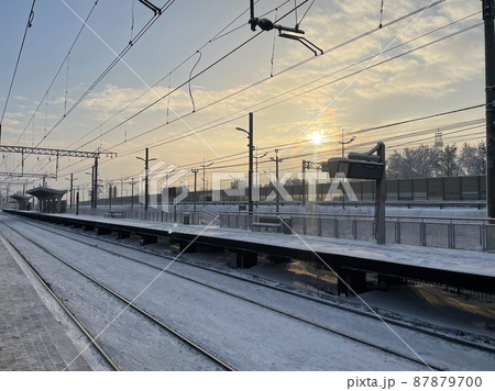 Empty railway platform without passengers in winter at the sunset. Empty railway platform without passengers in winter at the sunset. 87879700