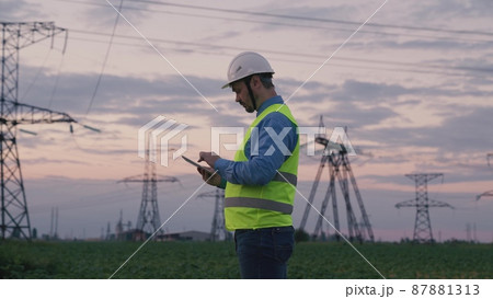 technology concept with high voltage power lines. electrical engineer helmet digital tablet sunset. power engineer power plant high voltage voltage energy. concept electrical engineer working sunset technology concept with high voltage power lines. electrical engineer helmet digital tablet sunset. power engineer power plant high voltage voltage energy. concept electrical engineer working sunset 87881313