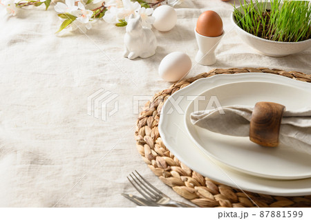 Easter festive dinner with egg, bunny, fresh flowers. 87881599