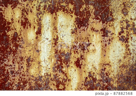 Brown abstract background with beige orange red hues. A weathered, rust-eaten textured sheet of metal with traces of paint residue. Brown abstract background with beige orange red hues. A weathered, rust-eaten textured sheet of metal with traces of paint residue. 87882568