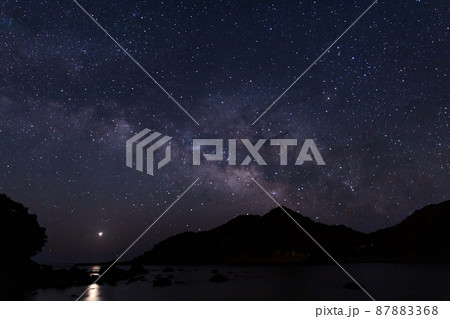 宮崎県日南市南郷町男女島がある夫婦浦海岸の上に広がる星空に横に流れる天の川と海を照らす金星 87883368