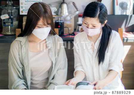 カフェで談笑するマスクをした母と娘 カフェで談笑するマスクをした母と娘 87889329