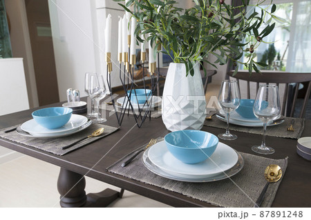 Modern dinning room interior with blue plate on wood table at home. Modern dinning room interior with blue plate on wood table at home. 87891248