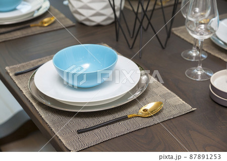 Modern dinning room interior with blue plate on wood table at home. Modern dinning room interior with blue plate on wood table at home. 87891253