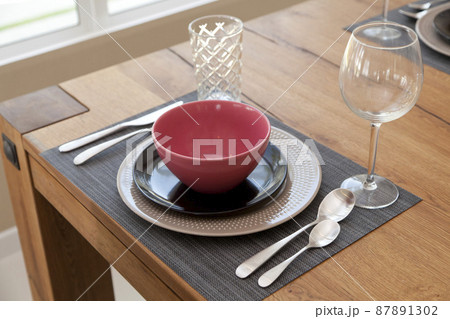 Elegant table set up for dinning room with red and black plate at home 87891302