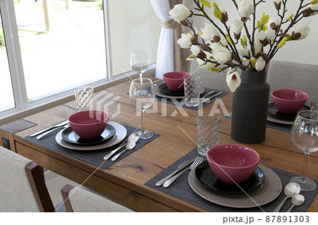 Elegant table set up for dinning room with red and black plate at home 87891303