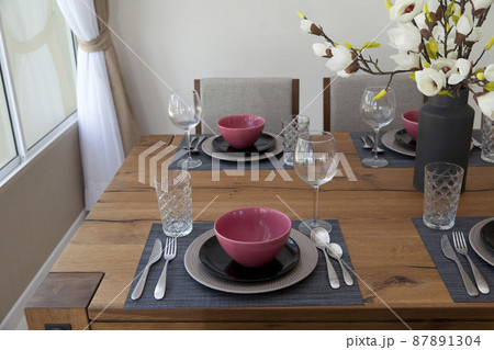 Elegant table set up for dinning room with red and black plate at home 87891304