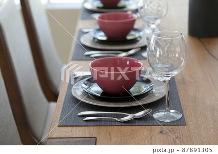 Elegant table set up for dinning room with red and black plate at home 87891305