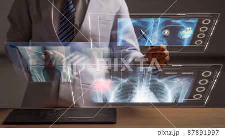 Woman doctor reviewing a human anatomy on head up display, futuristic medical examination hologram Woman doctor reviewing a human anatomy on head up display, futuristic medical examination hologram 87891997