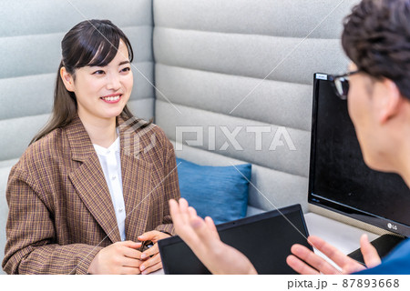 プライベートブースで話をするビジネスマンとビジネスウーマン プライベートブースで話をするビジネスマンとビジネスウーマン 87893668
