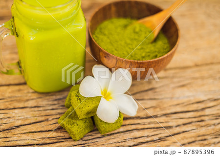 Green tea latte with ice in mason jar, matcha powder and candy made of matcha on wooden background. Homemade Iced Matcha Latte Tea with Milk zero waste Green tea latte with ice in mason jar, matcha powder and candy made of matcha on wooden background. Homemade Iced Matcha Latte Tea with Milk zero waste 87895396
