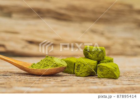 Matcha powder and candy made of matcha on wooden background. Homemade Matcha Matcha powder and candy made of matcha on wooden background. Homemade Matcha 87895414