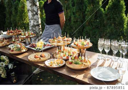A table of various snacks, sandwiches, strawberries and other types of snacks. 87895851