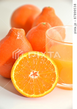 ポンカンに似た柑橘類ミネオラとそのカットとジュース ポンカンに似た柑橘類ミネオラとそのカットとジュース 87899538