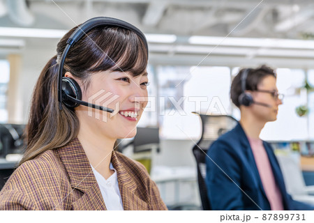 フリーアドレスのオフィスで仕事をするビジネスマンとビジネスウーマン フリーアドレスのオフィスで仕事をするビジネスマンとビジネスウーマン 87899731