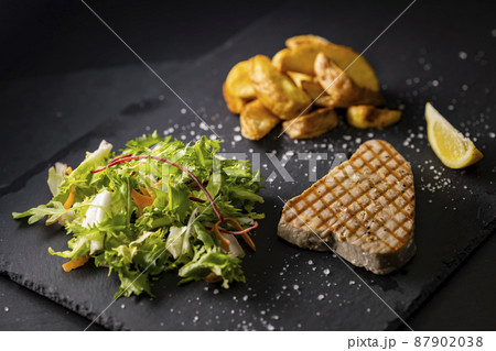 tuna steak with salad and spicy potatoes tuna steak with salad and spicy potatoes 87902038