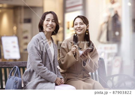 コートを着てスマホを見る女性 親子 母娘 コートを着てスマホを見る女性 親子 母娘 87903822
