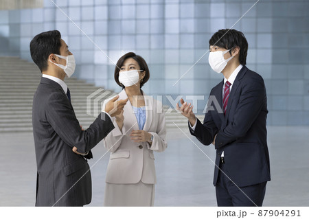 マスクをして話をする3人のビジネスパーソン マスクをして話をする3人のビジネスパーソン 87904291