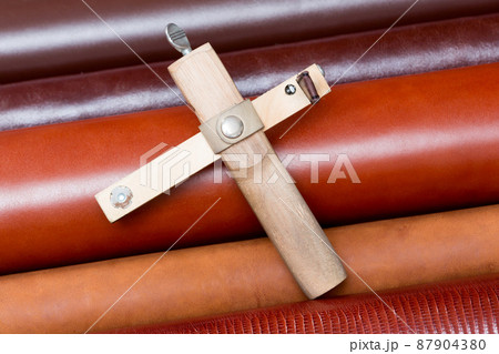 The strap cutter on leather brown pieces. 87904380