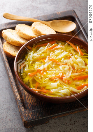 Sopa Juliana is a hearty Portuguese vegetable soup made with a combination of cabbage, carrots, turnips, onions, potatoes and spices closeup in the plate. Vertical Sopa Juliana is a hearty Portuguese vegetable soup made with a combination of cabbage, carrots, turnips, onions, potatoes and spices closeup in the plate. Vertical 87904576