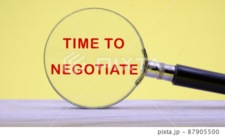 time to negotiate text on a yellow background through a magnifying glass time to negotiate text on a yellow background through a magnifying glass 87905500