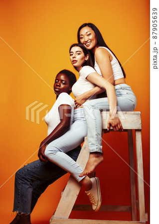 diverse multi nation girls group, teenage friends company cheerful having fun, happy smiling, cute posing on yellow background, lifestyle people concept, african-american, asian and caucasian 87905639