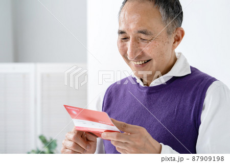 通帳を見て喜ぶシニア男性 87909198