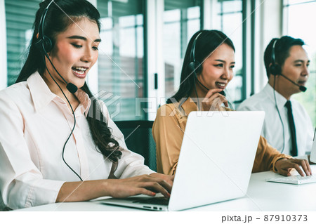 Business people wearing headset working actively in office Business people wearing headset working actively in office 87910373
