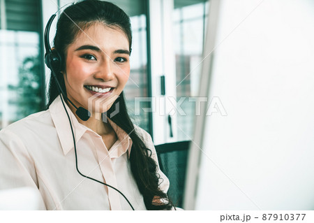 Businesswoman wearing headset working actively in office 87910377