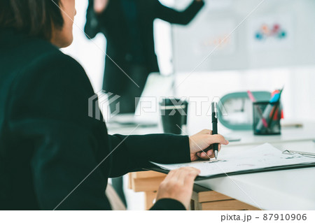 Businesswoman in business meeting writing paper proficiently at office room . 87910906