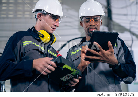 Group of factory job workers using adept machine equipment in a workshop Group of factory job workers using adept machine equipment in a workshop 87910978