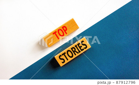Top stories symbol. Concept words Top stories on wooden blocks on a beautiful blue table white background. Business story and top stories concept, copy space. 87912796