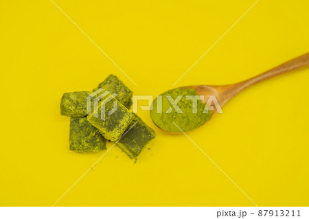 Spoon with matcha powder and candy made of matcha on yellow background. Homemade Matcha Spoon with matcha powder and candy made of matcha on yellow background. Homemade Matcha 87913211