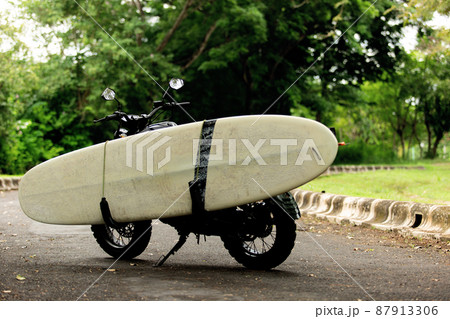 motorcycle with a surfboard. motorcycle with a surfboard. 87913306