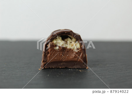 incision chocolate case candy stuffed with chocolate pralines and crushed peanuts close-up on a gray background with space for copyspace text. Chocolate Day Sweet Homemade Desserts 87914022